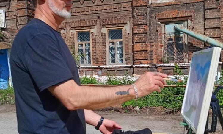 Алексей Харитонов на фоне здания «Жилой дом»