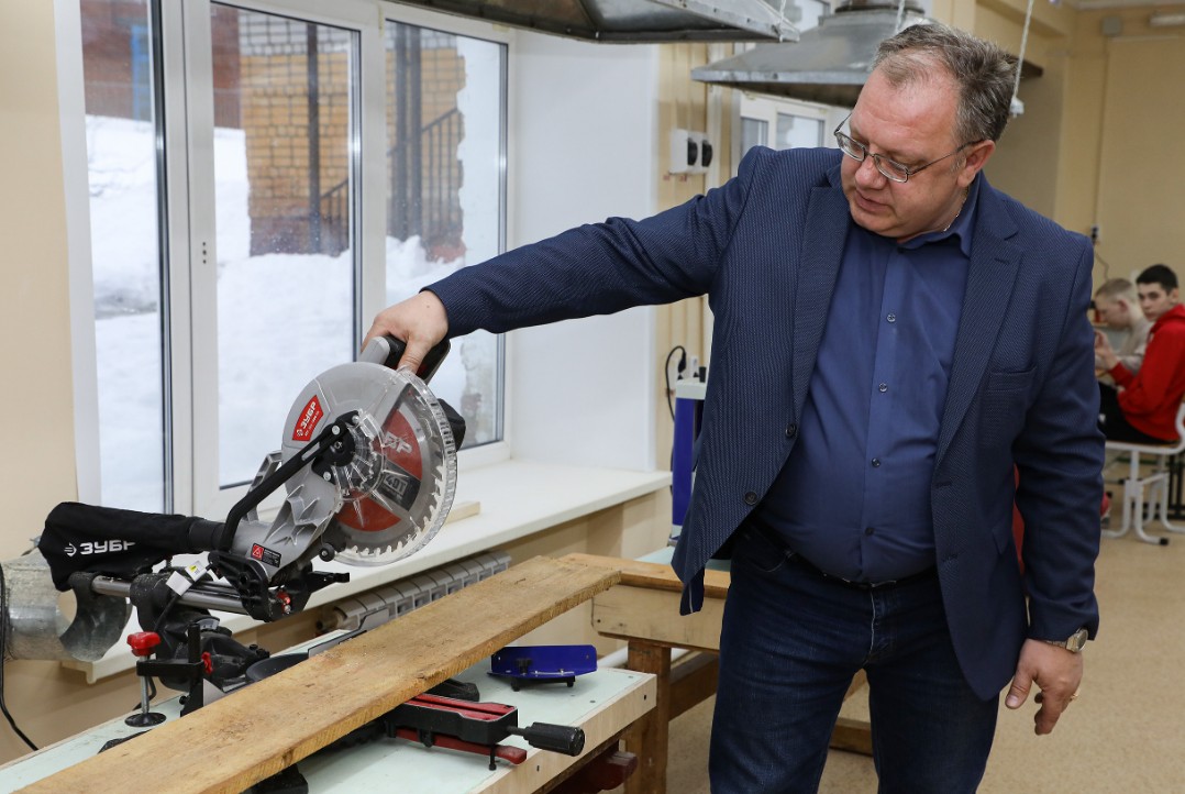 Виталий Булатов, учитель технологи, показывает работу станков